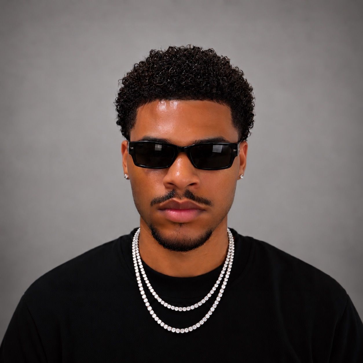 QAMAZI wearing black sunglasses and stacked diamond tennis chains